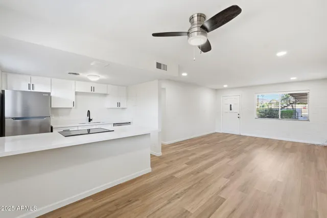 a kitchen with stainless steel appliances kitchen island a sink and refrigerator