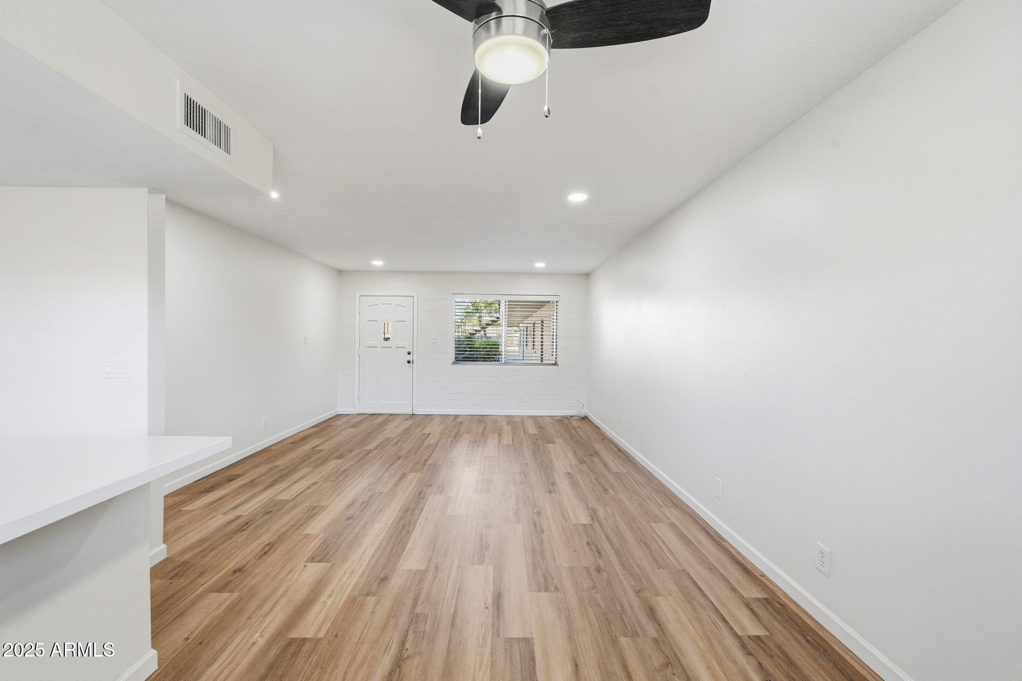 6544 North 12th Street, Unit 19 Phoenix, AZ 85014 - Photo 12 of 44 an empty room with wooden floor ceiling fan and windows