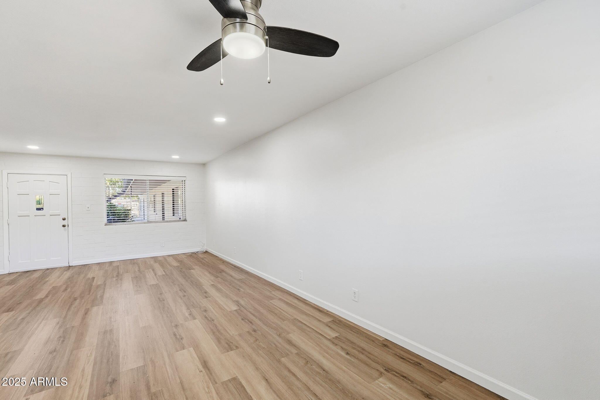 6544 North 12th Street, Unit 19 Phoenix, AZ 85014 - Photo 14 of 44 an empty room with wooden floor ceiling fan and windows