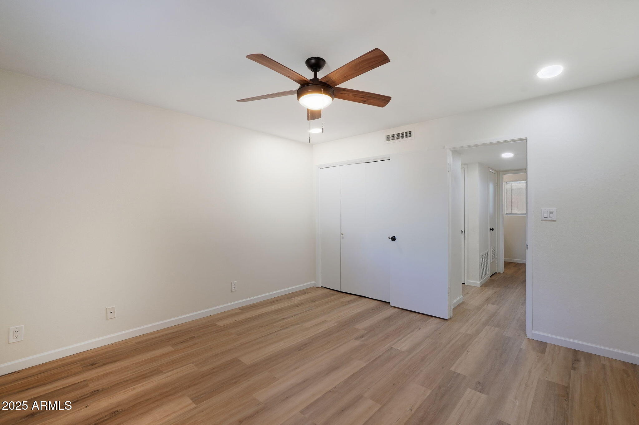 6544 North 12th Street, Unit 19 Phoenix, AZ 85014 - Photo 18 of 44 an empty room with wooden floor and ceiling fan