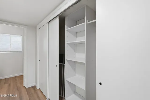 a view of walk in closet with empty racks