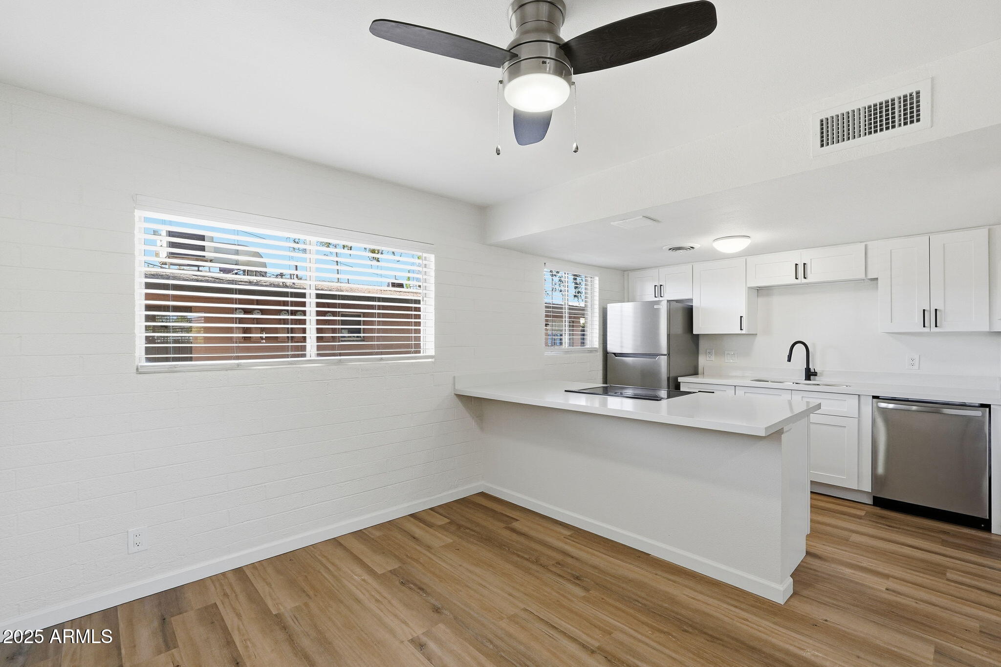 6544 North 12th Street, Unit 19 Phoenix, AZ 85014 - Photo 3 of 44 a kitchen with stainless steel appliances granite countertop a sink cabinets a stove and a window