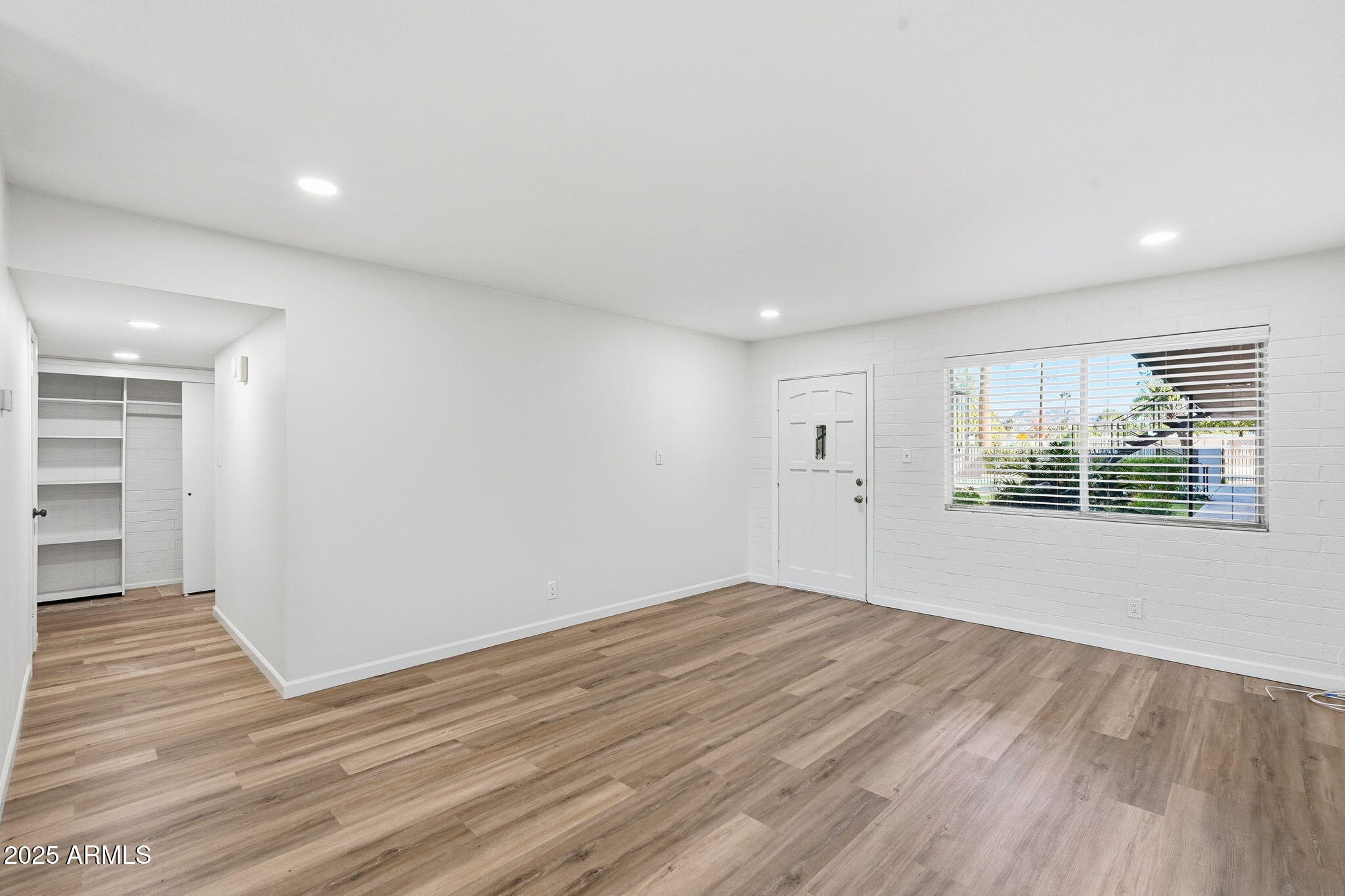 6544 North 12th Street, Unit 19 Phoenix, AZ 85014 - Photo 8 of 44 a view of an empty room with wooden floor and a window