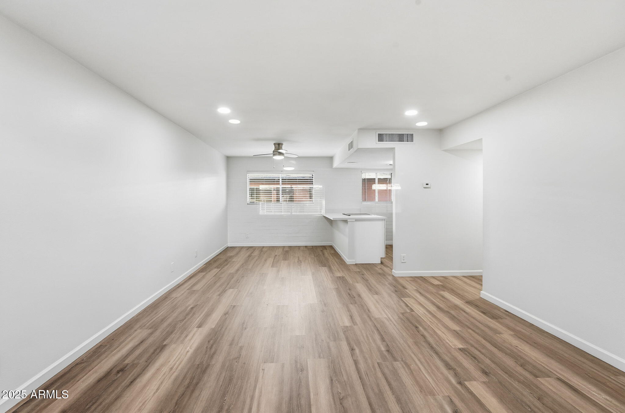 6544 North 12th Street, Unit 19 Phoenix, AZ 85014 - Photo 9 of 44 a view of kitchen and empty room with wooden floor