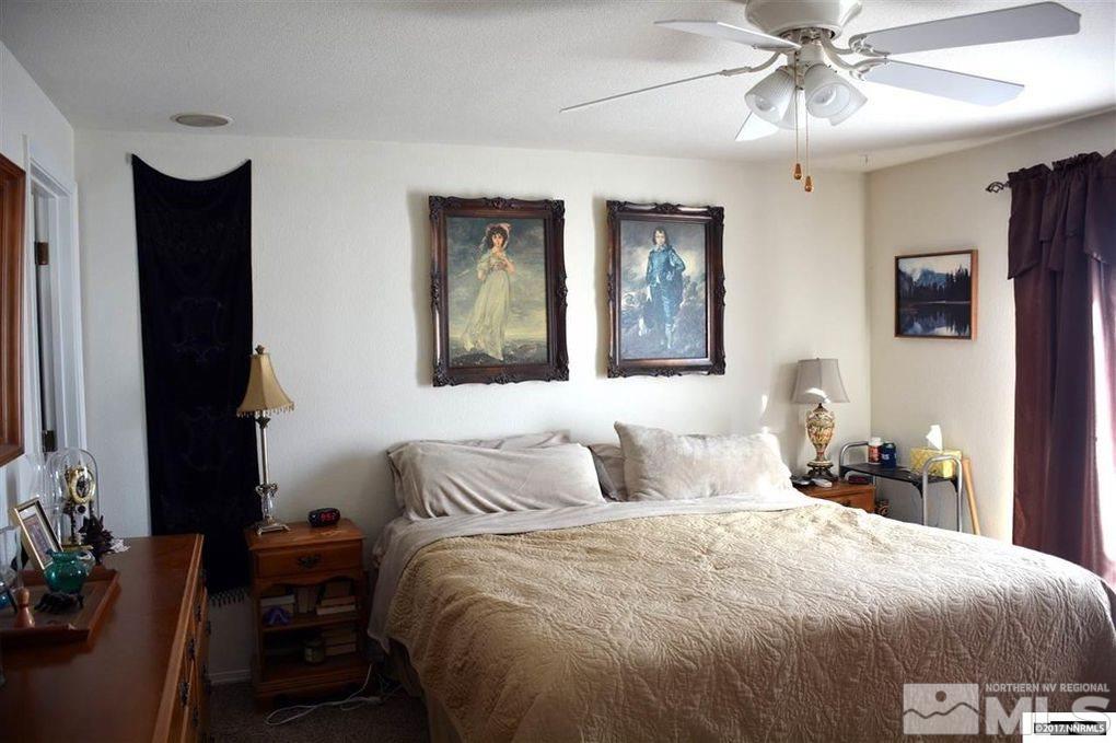 544 Yellow Jacket Road Dayton, NV 89403 - Photo 5 of 8 a bedroom with a bed and a chandelier