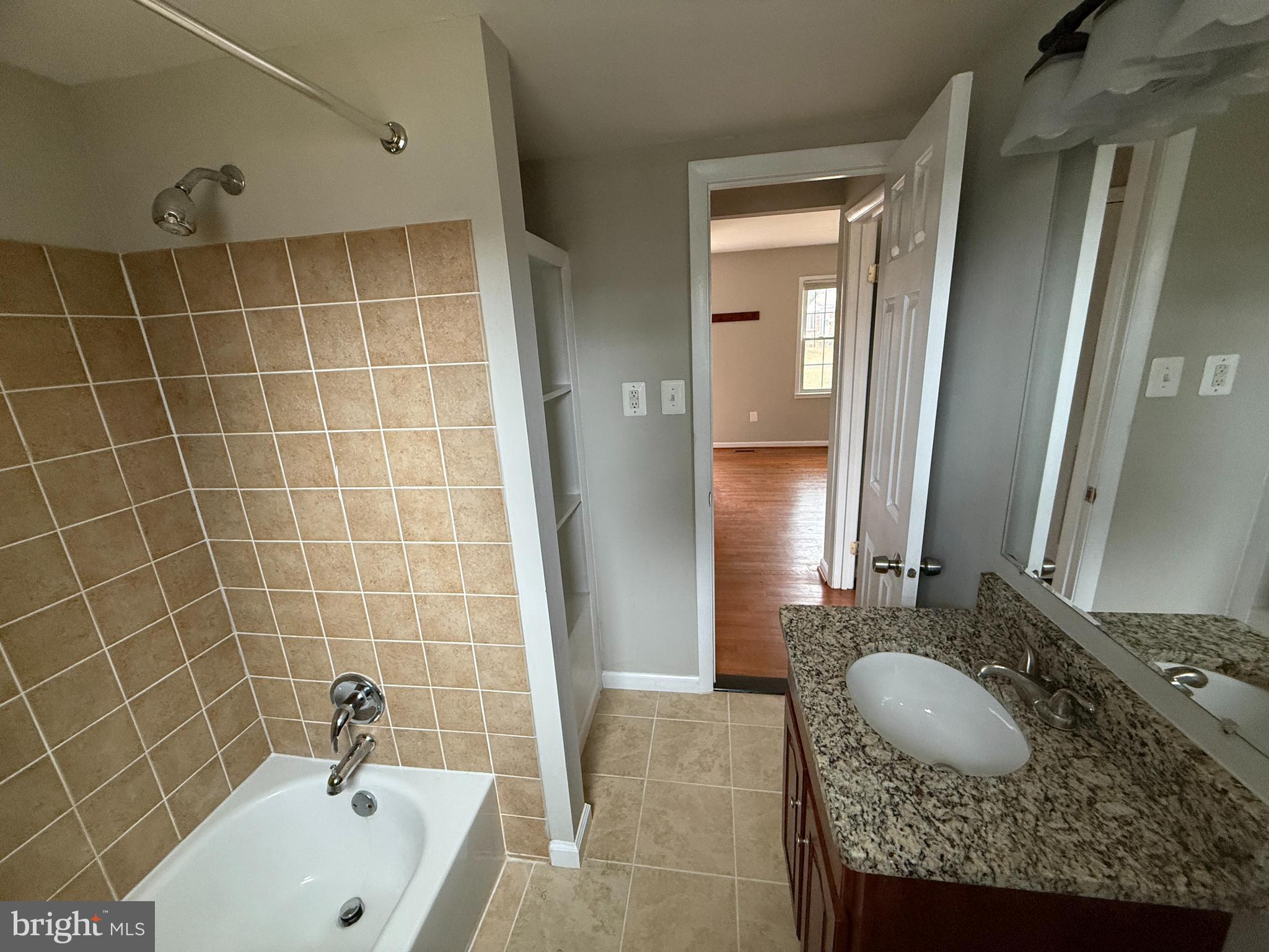 4542 Kingston Road Woodbridge, VA 22193 - Photo 4 of 15 a bathroom with a granite countertop sink a bathtub and mirror