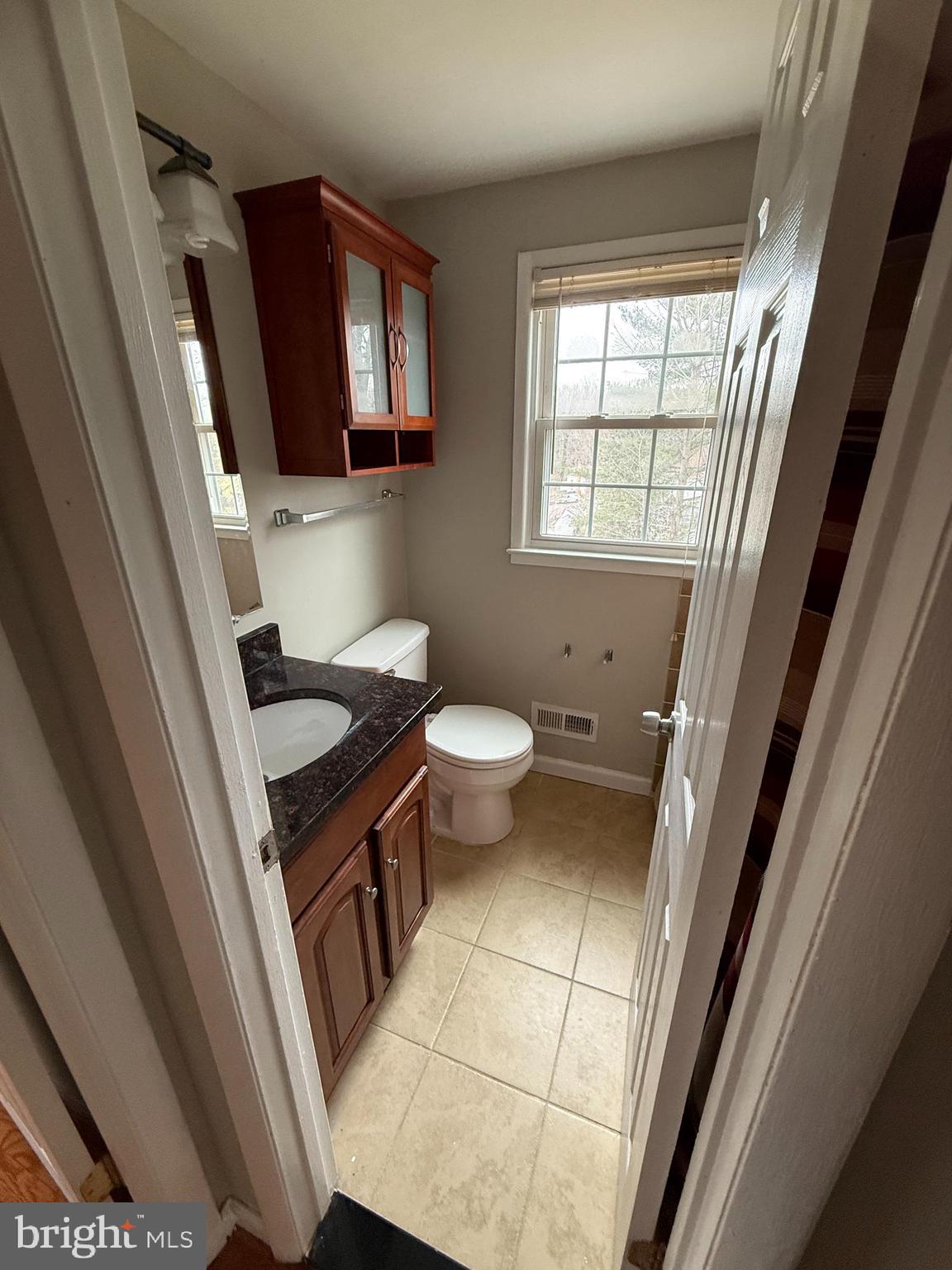 4542 Kingston Road Woodbridge, VA 22193 - Photo 8 of 15 a bathroom with a toilet a sink a toilet a mirror and a window
