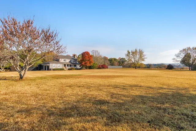a kitchen with stainless steel appliances granite countertop a refrigerator a stove and a sink with wooden floor
