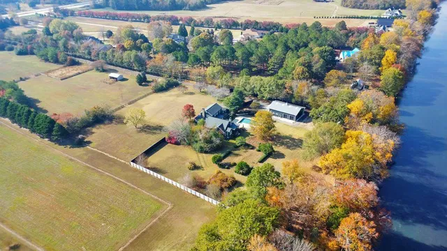a dining room with wooden floor a chandelier a wooden table and chairs