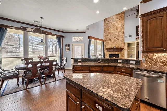 a kitchen with granite countertop stainless steel appliances a sink stove and cabinets