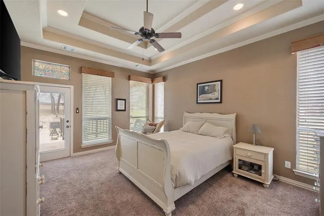a bedroom with a bed a dresser and a chandelier