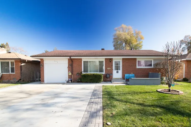 a front view of a house with a yard and potted plants