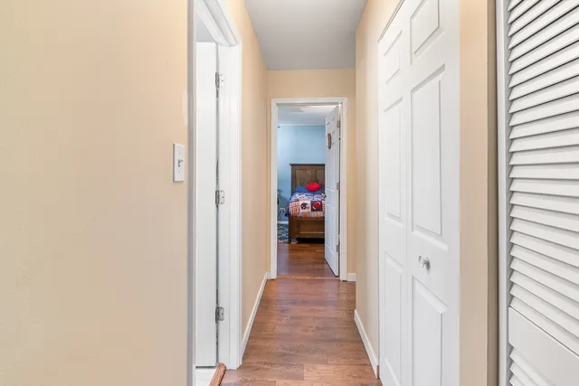 a view of a hallway with wooden floor and closet