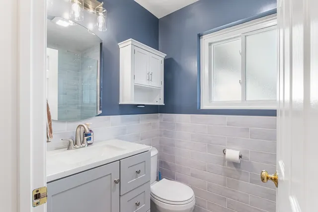 a bathroom with a sink a toilet and a mirror