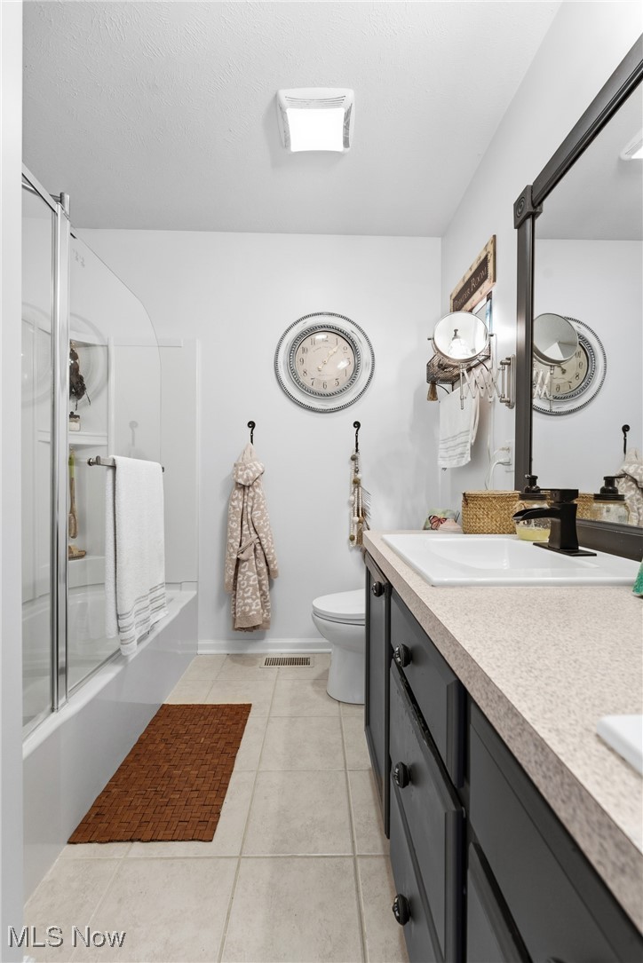 4038 Gardiner Run Akron, OH 44321 - Photo 24 of 38 Bathroom featuring double vanity, light tile patterned floors, and bath / shower combo with glass door