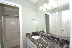 a bathroom with a granite countertop sink and a mirror