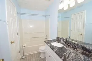 a bathroom with a granite countertop sink toilet and shower