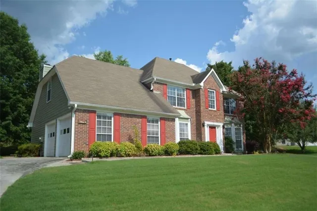 a front view of a house with a yard and trees
