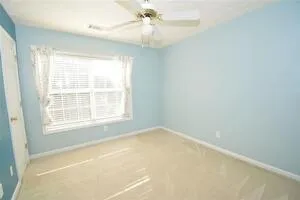 an empty room with a window and a fan