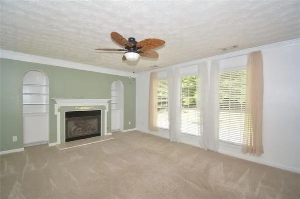 a view of an empty room with a fireplace and a window