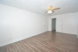 a view of a room with wooden floor and a ceiling fan