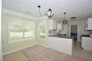 a kitchen with kitchen island white cabinets and appliances