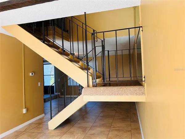 a kitchen with stainless steel appliances granite countertop a refrigerator a sink dishwasher a stove and a dining table with wooden floor
