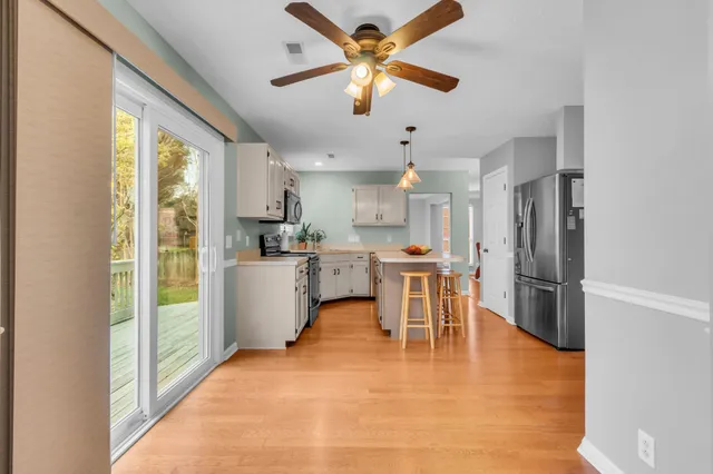 a kitchen with a table chairs refrigerator and cabinets