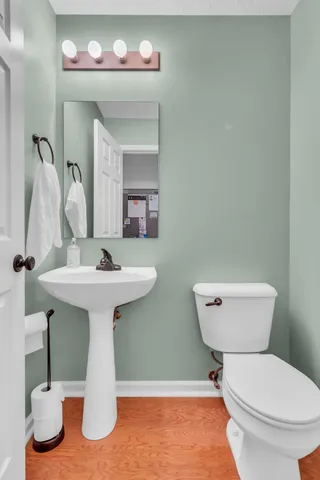 a bathroom with a toilet sink and mirror