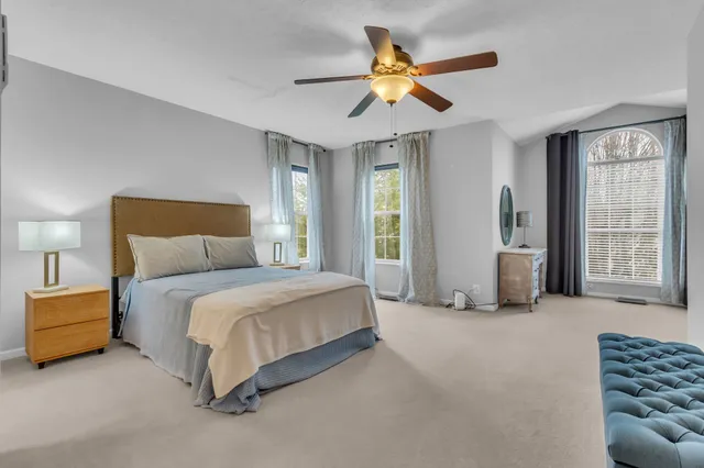 a spacious bedroom with a bed and a chandelier
