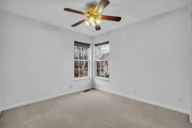 an empty room with a window and a fan