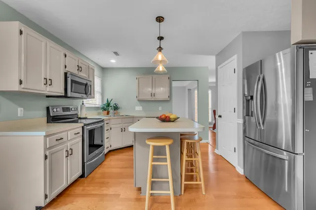 a kitchen with stainless steel appliances granite countertop a stove refrigerator and a sink