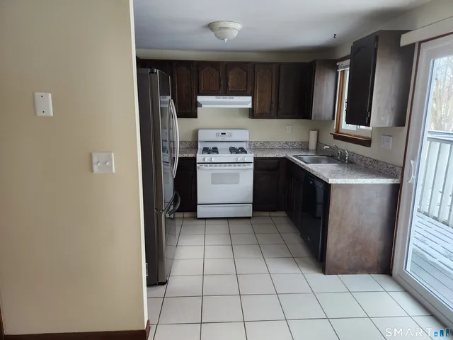 a kitchen with a stove a refrigerator and a sink