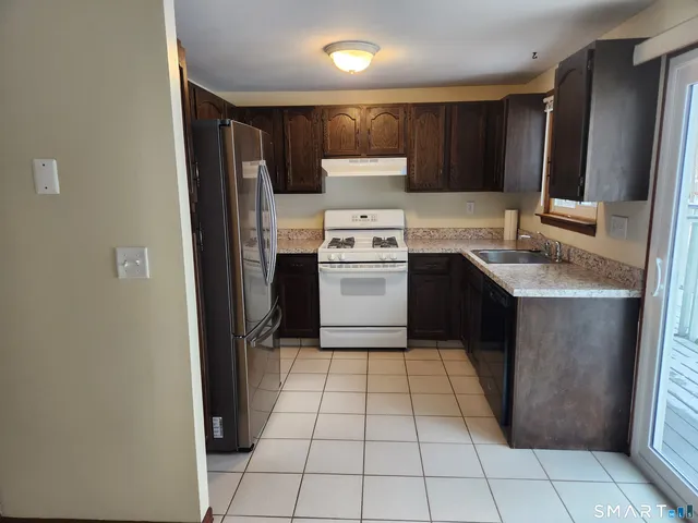 a kitchen with a refrigerator sink and cabinets