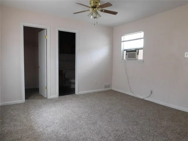 an empty room with closet and fan