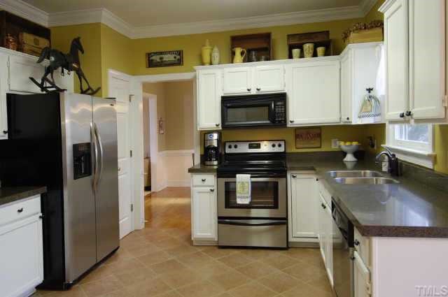 5017 Denham Court Raleigh, NC 27613 - Photo 4 of 11 a kitchen with a refrigerator stove and microwave
