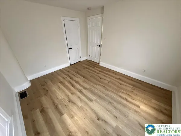 a view of empty room with wooden floor