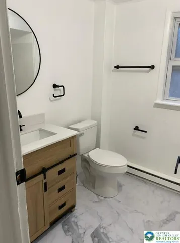 a bathroom with a toilet a sink and mirror