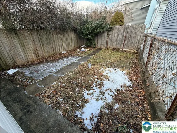a view of backyard with wooden fence