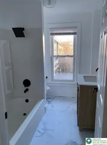 a bathroom with a window and a shower