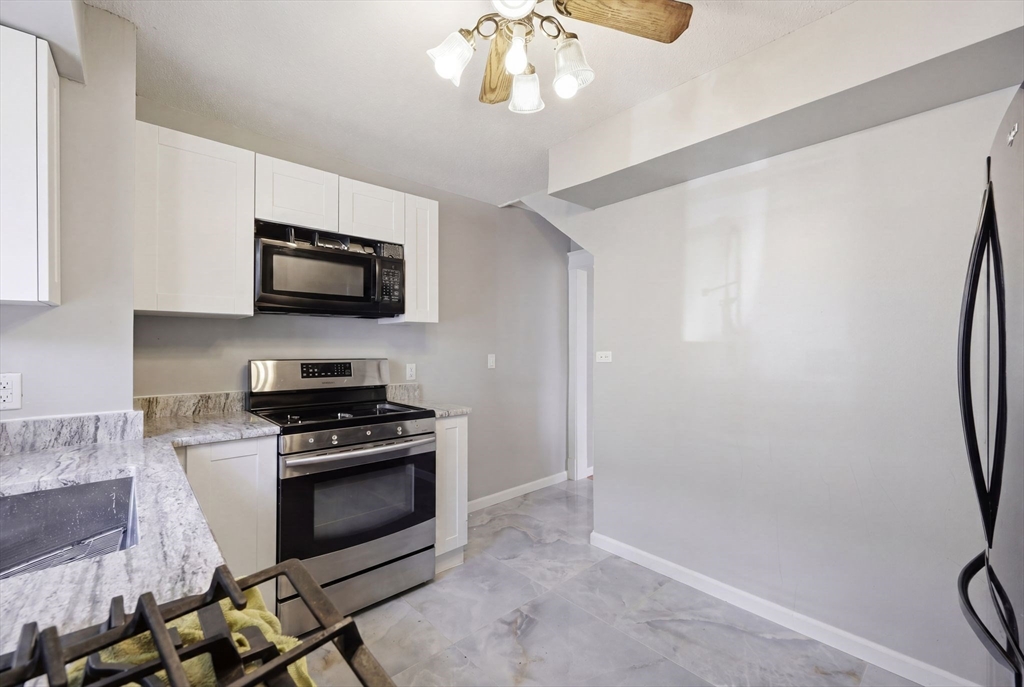 62 Kenyon Street Springfield, MA 01109 - Photo 14 of 26 a kitchen with a stove and a microwave