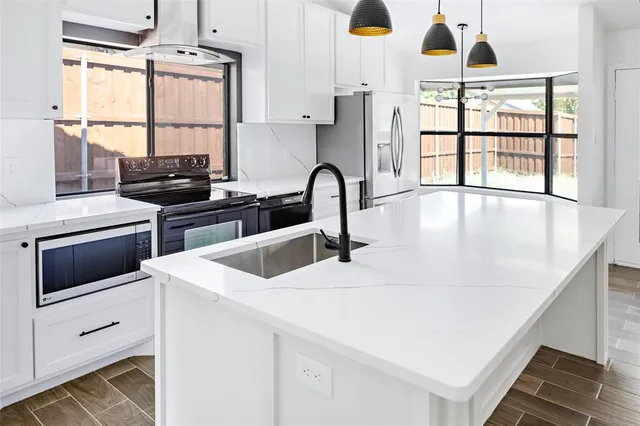 a kitchen with a stove a sink and a window