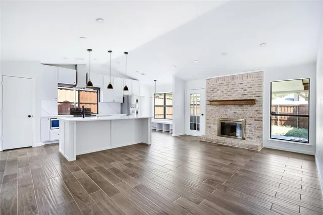 a large kitchen with cabinets wooden floor and a fireplace