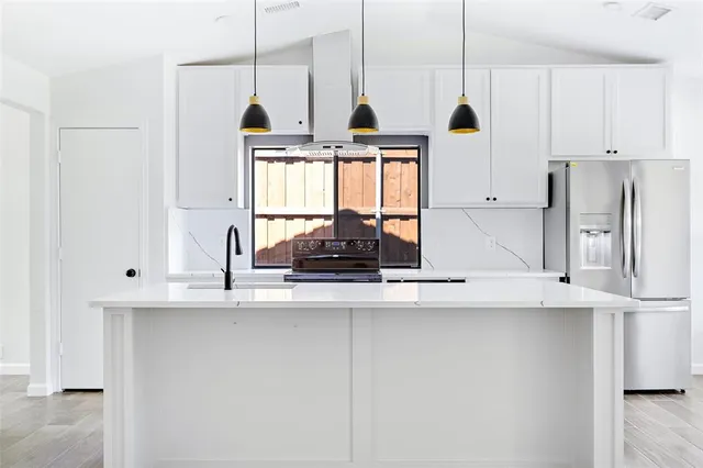 a kitchen with kitchen island a stove a sink and a window