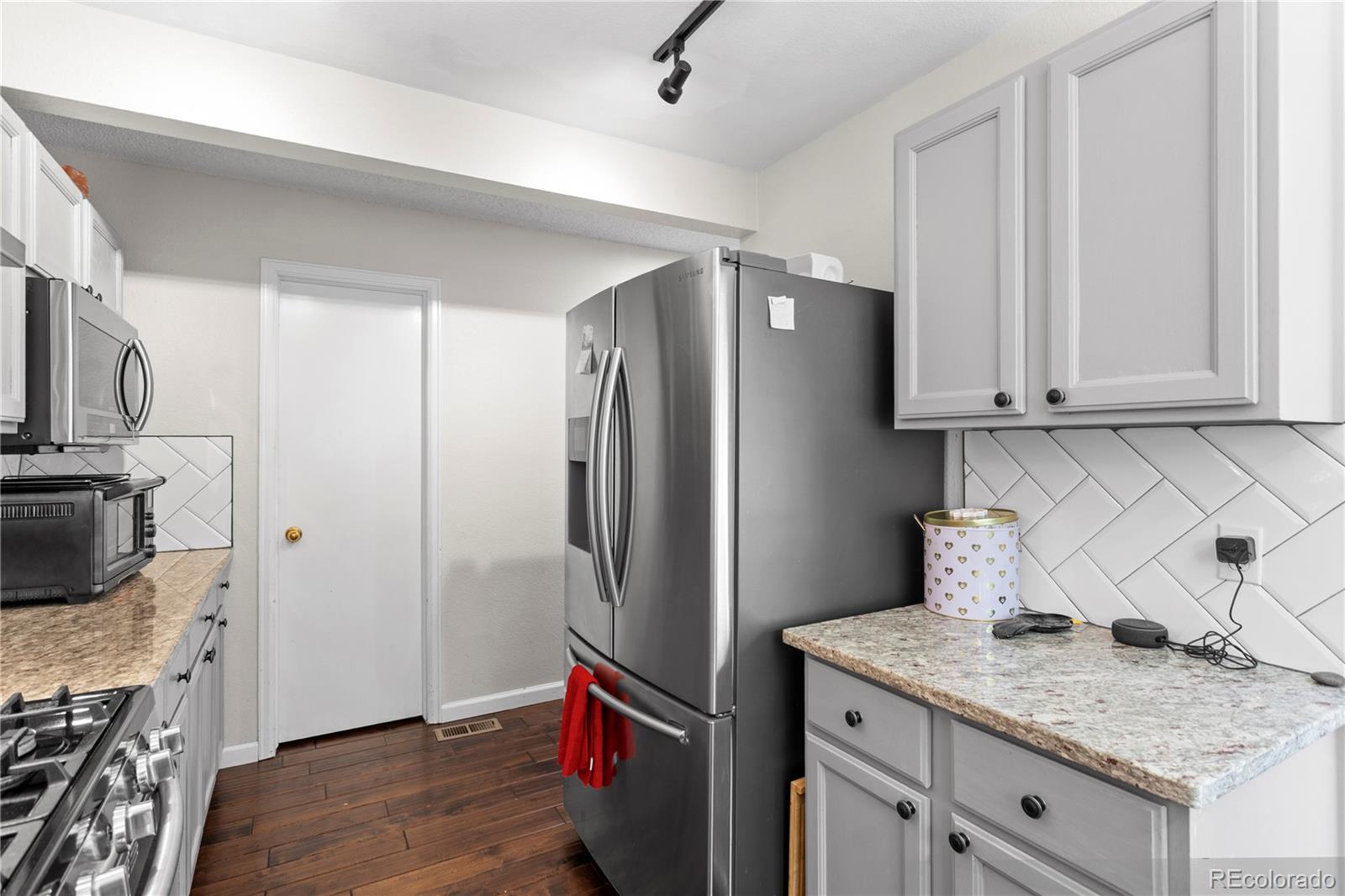 2212 Hyacinth Road Littleton, CO 80129 - Photo 17 of 44 a kitchen with stainless steel appliances granite countertop a refrigerator and a stove