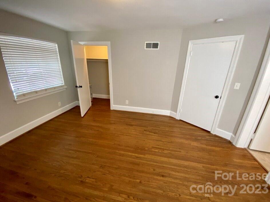 1708 Dilworth Road West, Unit 9 Charlotte, NC 28203 - Photo 12 of 14 an empty room with wooden floor and windows