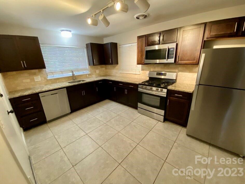 1708 Dilworth Road West, Unit 9 Charlotte, NC 28203 - Photo 4 of 14 a kitchen with stainless steel appliances granite countertop a refrigerator stove a sink dishwasher and a microwave