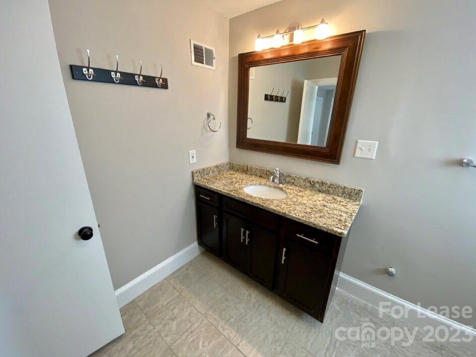 1708 Dilworth Road West, Unit 9 Charlotte, NC 28203 - Photo 9 of 14 a bathroom with a granite countertop sink and a mirror
