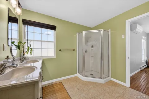 a bathroom with a granite countertop sink a mirror and a shower