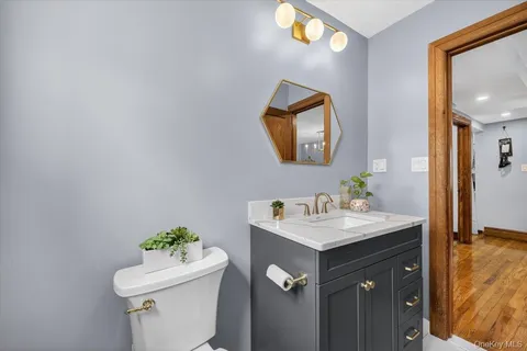 a bathroom with a sink vanity mirror and toilet